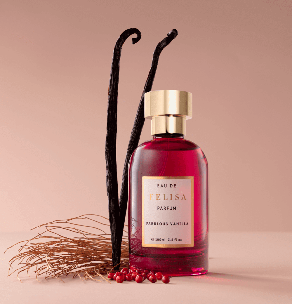 Frasco de Fabulous Vanilla ao lado de fava de baunilha, pimenta rosa e raízes secas, ingredientes da composição