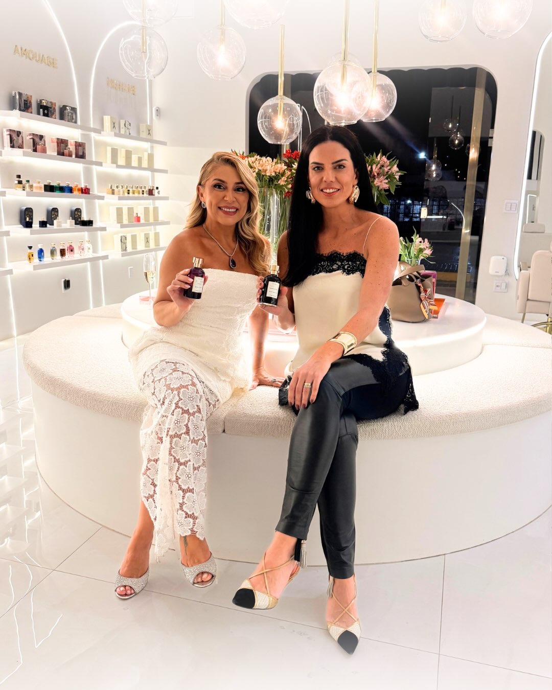 Duas convidadas seguram frascos FELISA durante a noite do FELISA On Tour, na Mell Alta Perfumaria em Goiânia