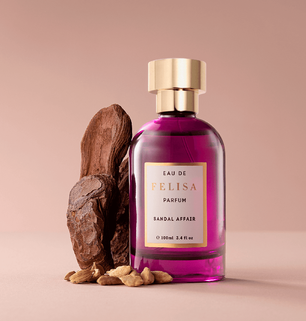 Frasco de Sandal Affair ao lado de madeira de sandalo e vagens de cardamomo, ingredientes da fragrancia, Felisa Beauty, perfumaria de nicho brasileira de luxo